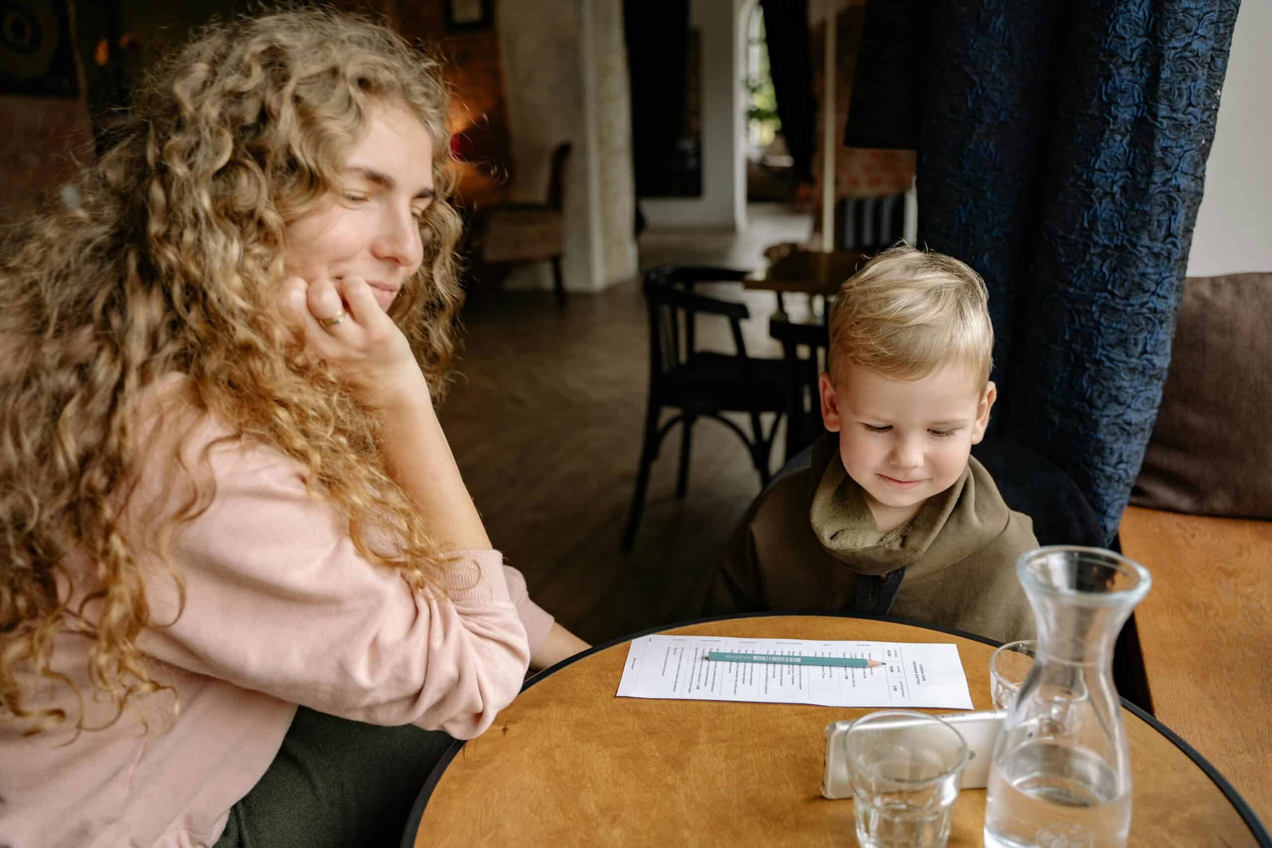 Woman at a restaurant looking at her son and smiling, cafe