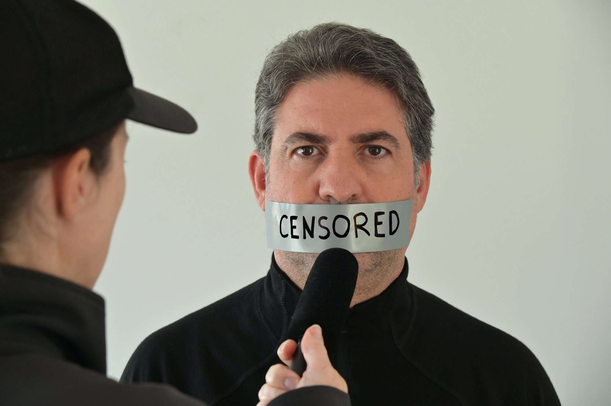 News reporter interviewing an eyewitness person that his information has being censored.