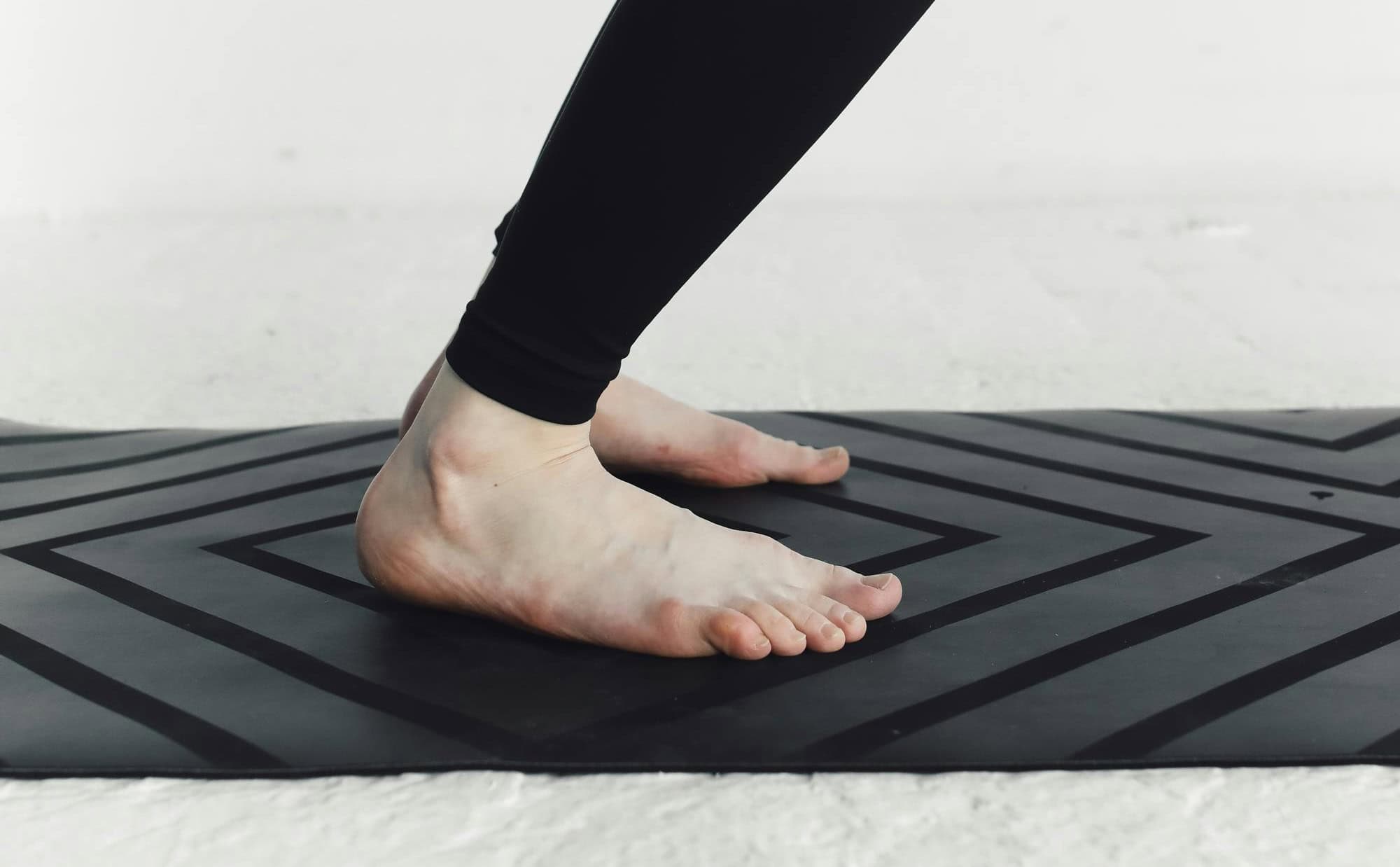 Cropped photo of bare feet on floormat, mat