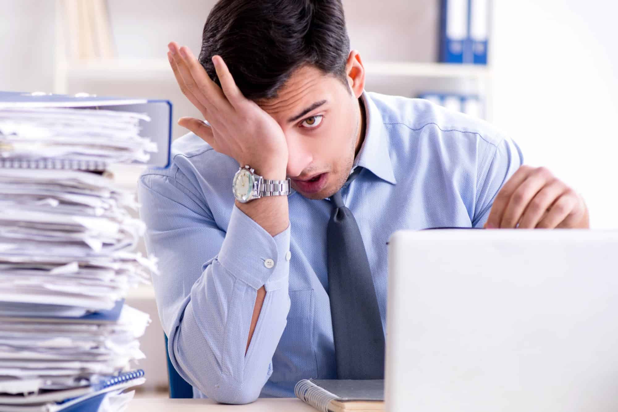 Extremely busy businessman working in office