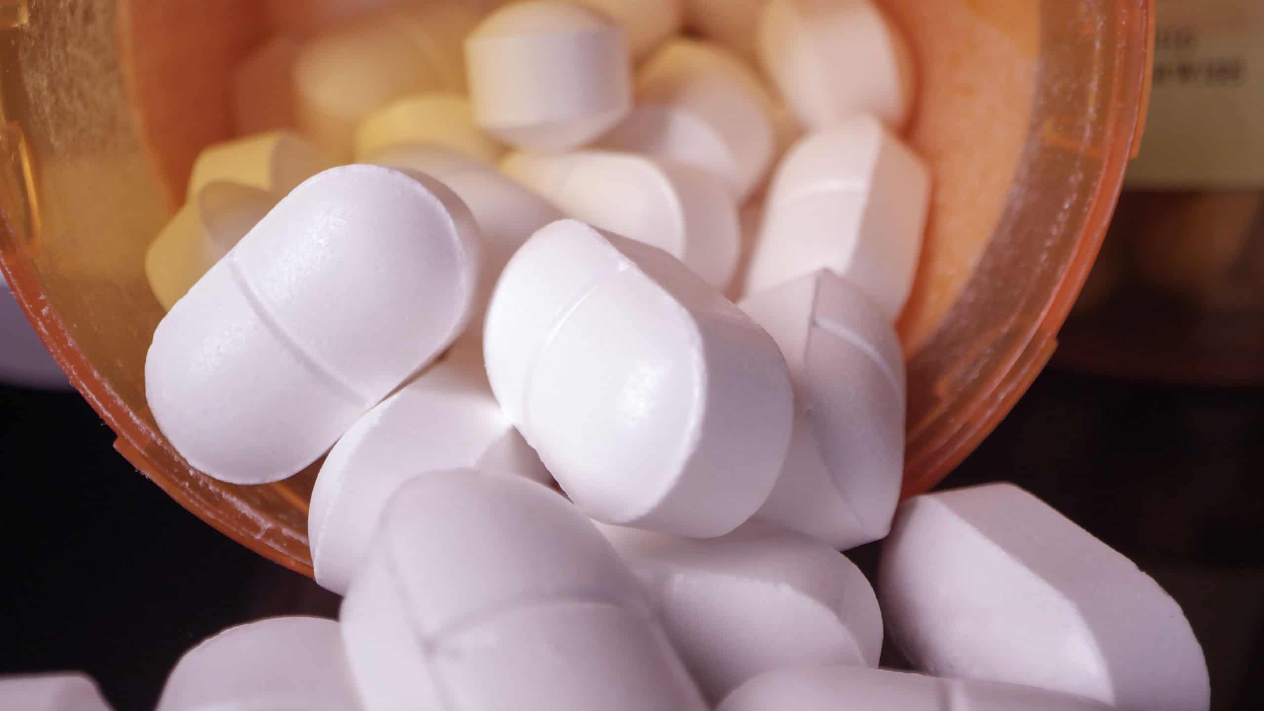 Prescription drugs poured out of bottle viewing them up close.