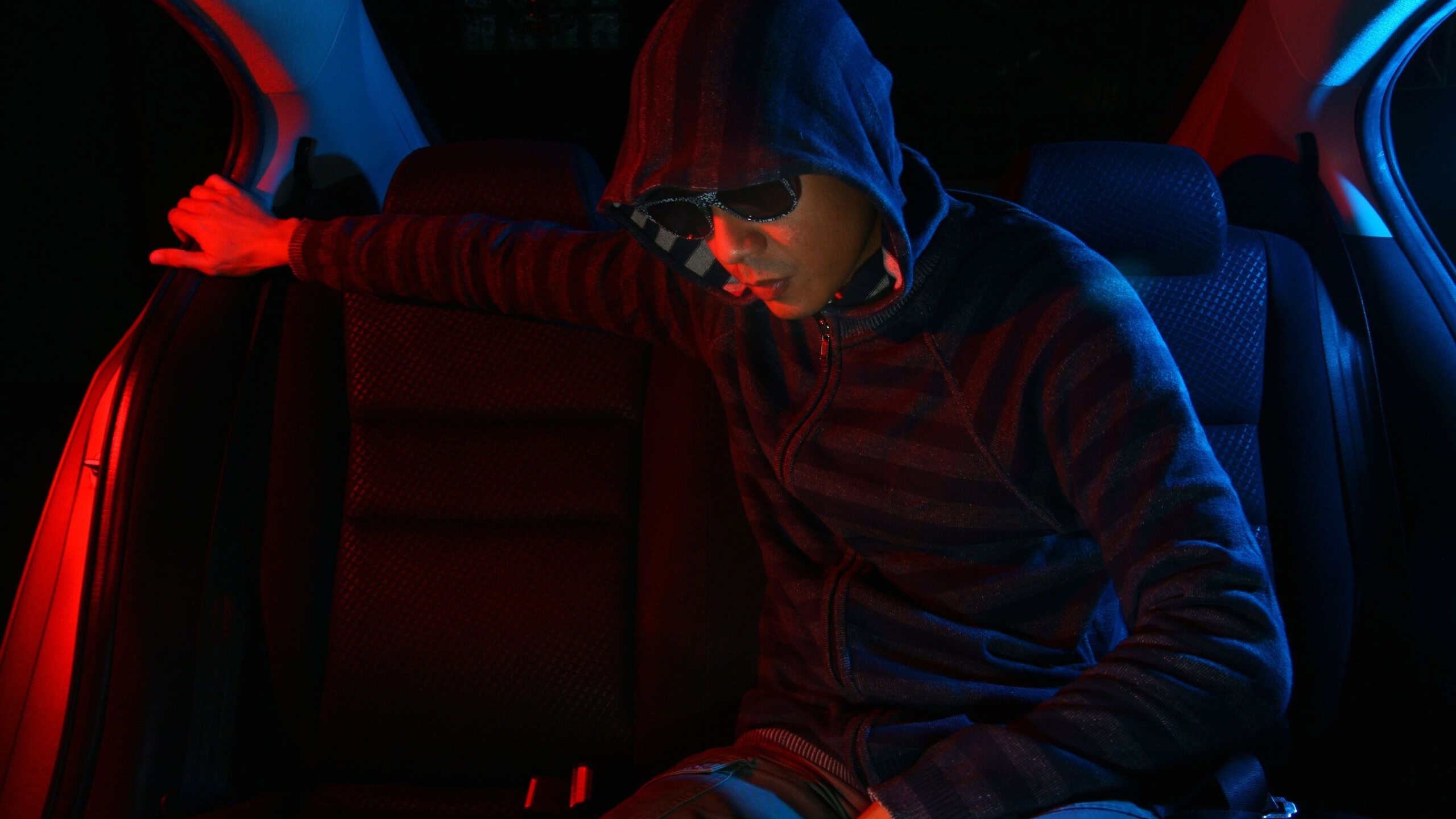 Man in the backseat of a car wearing a hoodie shirt Photo of a Man in the backseat of a car wearing a hoodie shirt