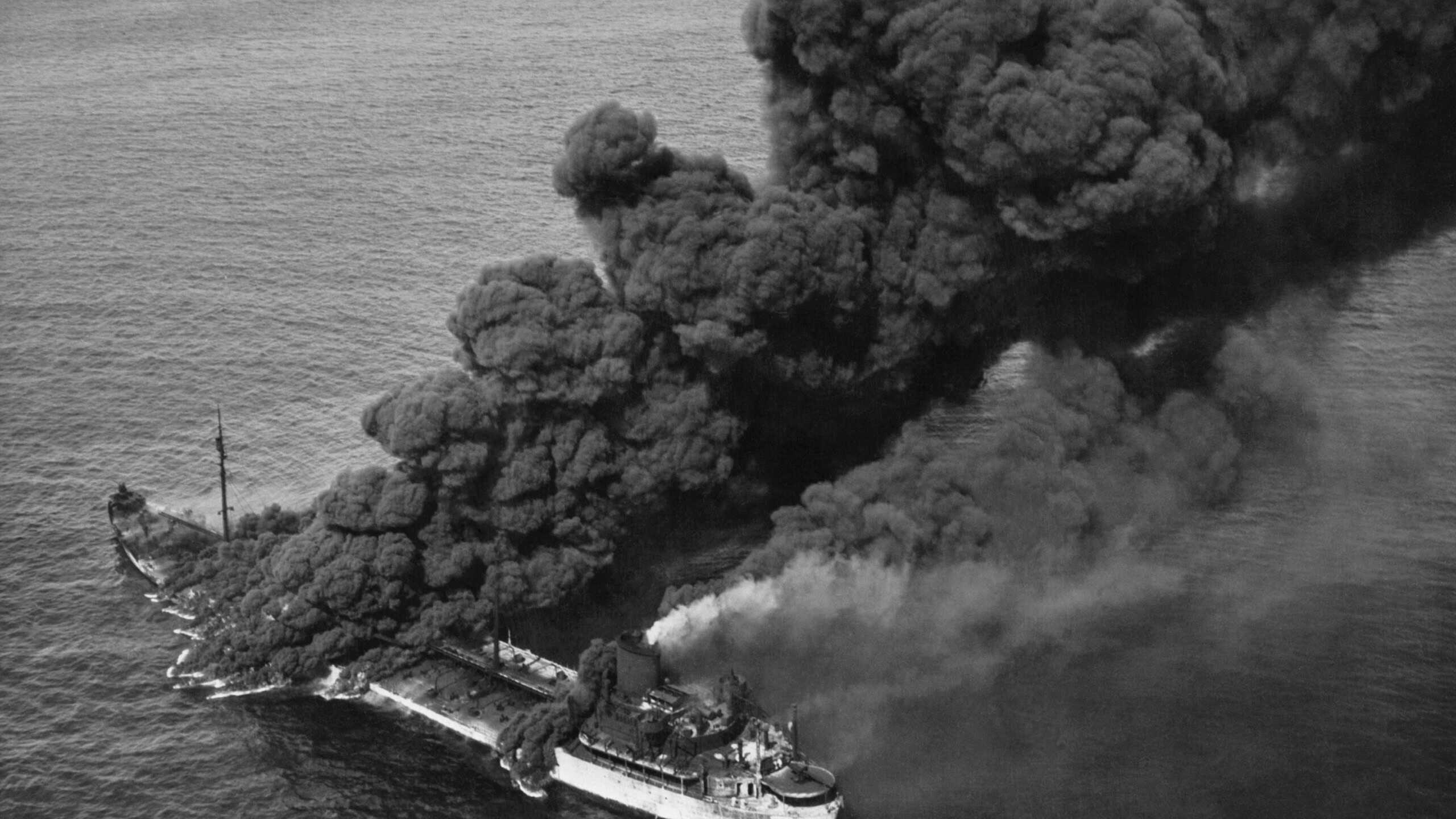 A torpedoed American tanker burning after an Axis submarine attack. Crew members brought the fire under control and the ship was towed to port for repair. Ca. 1942-43. World War 2.